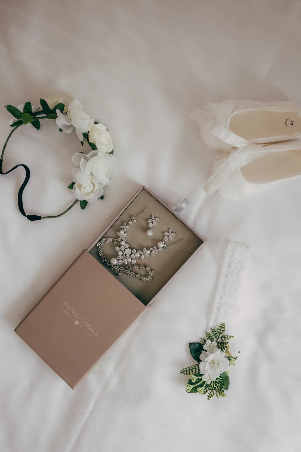 Brautschmuck, Haarband und Einladung als Flatlay arrangiert