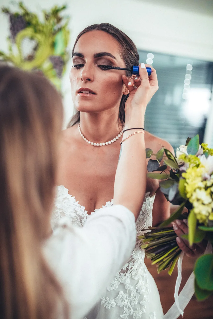 Visagistin legt beim Getting Ready letzte Hand an das Braut-Make-up